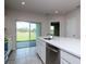 Kitchen with stainless steel appliances, white cabinets, and a sliding glass door to the backyard at 3062 Victoria Inlet Dr, Holiday, FL 34691