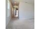Bright living room with plush carpet and neutral paint, leading to a tiled hallway at 3062 Victoria Inlet Dr, Holiday, FL 34691