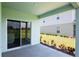 View of covered patio with sliding glass door and a lush lawn at 3062 Victoria Inlet Dr, Holiday, FL 34691