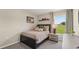 Cozy bedroom with a comfortable bed, bedside table, soft carpet, and a bright window view at 3071 Pink Gerbera Sq, Plant City, FL 33566