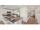Well-lit kitchen boasts stainless steel appliances, a functional island, and a view into the hallway at 3071 Pink Gerbera Sq, Plant City, FL 33566