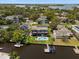Aerial view of a two-story home with a pool, patio, and private boat dock on the canal at 316 Hillpoint Dr, Palm Harbor, FL 34683