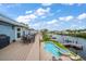 A backyard view of a waterfront home with a pool, hot tub, deck, grill and boat dock at 316 Hillpoint Dr, Palm Harbor, FL 34683