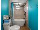 Compact bathroom featuring a modern tub and shower, with turquoise blue walls and tiled accents at 316 Hillpoint Dr, Palm Harbor, FL 34683