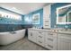 Bright bathroom with a soaking tub, double vanity with white cabinets, and modern fixtures at 316 Hillpoint Dr, Palm Harbor, FL 34683