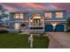 Two-story blue home with a well-manicured lawn, blue garage doors, and a welcoming front porch at sunset at 316 Hillpoint Dr, Palm Harbor, FL 34683
