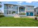 Charming two-story blue home with a well-manicured lawn, blue garage doors, and a welcoming front porch at 316 Hillpoint Dr, Palm Harbor, FL 34683