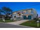 Charming two-story home with blue exterior, a manicured lawn and a two-car garage at 316 Hillpoint Dr, Palm Harbor, FL 34683