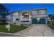 Charming two-story home with blue exterior, a manicured lawn and a two-car garage at 316 Hillpoint Dr, Palm Harbor, FL 34683