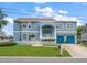 Charming two-story blue home with a well-manicured lawn, blue garage doors, and a welcoming front porch at 316 Hillpoint Dr, Palm Harbor, FL 34683
