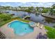 Aerial view of a backyard pool and hot tub with waterfront access and private dock in a residential neighborhood at 316 Hillpoint Dr, Palm Harbor, FL 34683