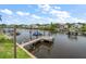 Waterfront view features a dock with a jet ski lift and boat mooring on a sunny day at 316 Hillpoint Dr, Palm Harbor, FL 34683