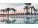 Resort-style pool with lounge chairs and palm trees reflecting in the clear water at 32417 Welling Blade Loop, Wesley Chapel, FL 33545