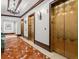 Hallway with marble floors and three gold elevator doors with a chandelier on the ceiling at 345 Bayshore Blvd # 1807, Tampa, FL 33606