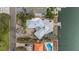 Aerial view of a waterfront home featuring a screened-in pool, boat dock, and well manicured yard at 3830 46Th S Ave, St Petersburg, FL 33711