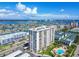 High rise condominium building aerial shot with community pool and expansive water views in background at 400 Island Way # 502, Clearwater Beach, FL 33767