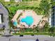 Aerial view of a swimming pool and deck area surrounded by lush landscaping at 400 Island Way # 502, Clearwater Beach, FL 33767