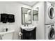 A bathroom vanity with black cabinets and stacked washer/dryer at 400 Island Way # 502, Clearwater Beach, FL 33767