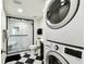 Bathroom featuring black and white tile, glass shower, and in-unit laundry at 400 Island Way # 502, Clearwater Beach, FL 33767