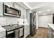 Beautiful kitchen with stainless steel appliances, white cabinets, marble backsplash, and hardwood floors at 400 Island Way # 502, Clearwater Beach, FL 33767