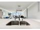 Bright condo featuring a modern kitchen with stainless steel sink, quartz countertop, and views of the living area and balcony at 400 Island Way # 502, Clearwater Beach, FL 33767