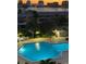 Night view of the community pool with lounge chairs and the waterway with city lights in the background at 400 Island Way # 502, Clearwater Beach, FL 33767