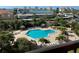 Bright community pool with lounge chairs and umbrellas with the intercoastal waterway in the background at 400 Island Way # 502, Clearwater Beach, FL 33767