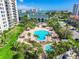 Aerial view of sparkling blue community pool surrounded by lush landscaping and comfortable lounge chairs at 400 Island Way # 502, Clearwater Beach, FL 33767
