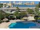 Resort-style pool featuring crystal blue water, lounge chairs, and tiki umbrellas at 400 Island Way # 502, Clearwater Beach, FL 33767