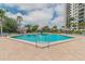 Beautiful in-ground pool near a high rise, lined with trees and sun umbrellas for a relaxing retreat at 400 Island Way # 502, Clearwater Beach, FL 33767