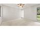 Bright and spacious bedroom with large windows, a ceiling fan and soft carpet, ready for personalization at 440 Lakeview Dr # 34, Palm Harbor, FL 34683