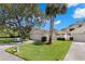 Inviting single-story home featuring a well-maintained lawn, mature trees, and attached garage at 440 Lakeview Dr # 34, Palm Harbor, FL 34683