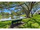 Scenic pond view with a bench in the foreground and large trees providing shade along the water at 440 Lakeview Dr # 34, Palm Harbor, FL 34683