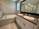 Bright bathroom featuring double sinks, granite counters, a bathtub, and a glass-enclosed shower at 4448 Globe Thistle, Tampa, FL 33619