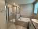 Well-lit bathroom showcasing a glass shower enclosure and a soaking tub at 4448 Globe Thistle, Tampa, FL 33619