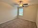 Spare bedroom featuring a ceiling fan, neutral carpeting, and a window at 4448 Globe Thistle, Tampa, FL 33619