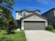 Well-maintained two-story home with a driveway, attached garage, manicured lawn, and trimmed bushes at 4448 Globe Thistle, Tampa, FL 33619