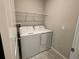 A utility room with a washer, dryer, and a wire shelf at 4448 Globe Thistle, Tampa, FL 33619