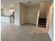 Open-concept living space with tile flooring and staircase, seamlessly connecting to the modern kitchen at 4448 Globe Thistle, Tampa, FL 33619