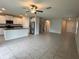Open-concept living room with tile floors, a ceiling fan, and a view of the kitchen at 4448 Globe Thistle, Tampa, FL 33619