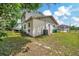 Home's backyard featuring the siding, an A/C Unit, a patio and lush green grass at 4612 E Seneca Ave, Tampa, FL 33617