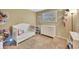 Cozy Bedroom with white crib, dresser, soft carpet, and natural light at 4612 E Seneca Ave, Tampa, FL 33617
