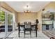 Well-lit dining room with a modern chandelier and sliding glass doors to the backyard at 4612 E Seneca Ave, Tampa, FL 33617