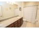 Bathroom featuring a granite-topped vanity, modern fixtures, and patterned shower curtain at 5003 Wabash Pl, Riverview, FL 33578