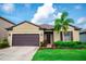 Charming single-story home featuring a well-manicured lawn, lovely flower beds, and a two-car garage at 5003 Wabash Pl, Riverview, FL 33578