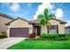 Attractive one-story house with a neatly kept yard, vibrant flowers, and a convenient attached garage at 5003 Wabash Pl, Riverview, FL 33578