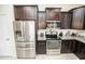 This kitchen features stainless steel appliances, granite countertops, and dark wood cabinetry at 5003 Wabash Pl, Riverview, FL 33578
