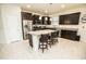 Bright kitchen features a center island with granite countertops, stainless steel appliances, and dark wood cabinetry at 5003 Wabash Pl, Riverview, FL 33578