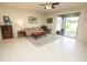 A cozy living room with tile floors, a sliding glass door to the patio, and neutral-toned furniture at 5003 Wabash Pl, Riverview, FL 33578
