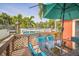Outdoor deck with dining set and umbrella, overlooking pool and canal; perfect for waterfront relaxation at 51 Cypress Dr, Palm Harbor, FL 34684
